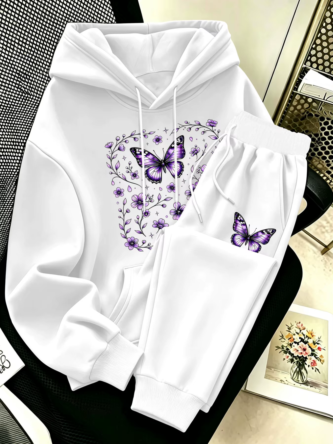 Conjunto de duas peças para mulher, composto por um casaco com capuz e calças de treino, com um estampado de borbolet...